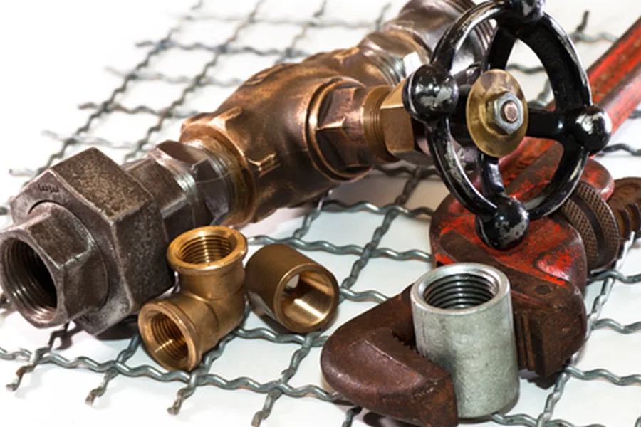 Brass and iron pipe fittings and a pipe wrench