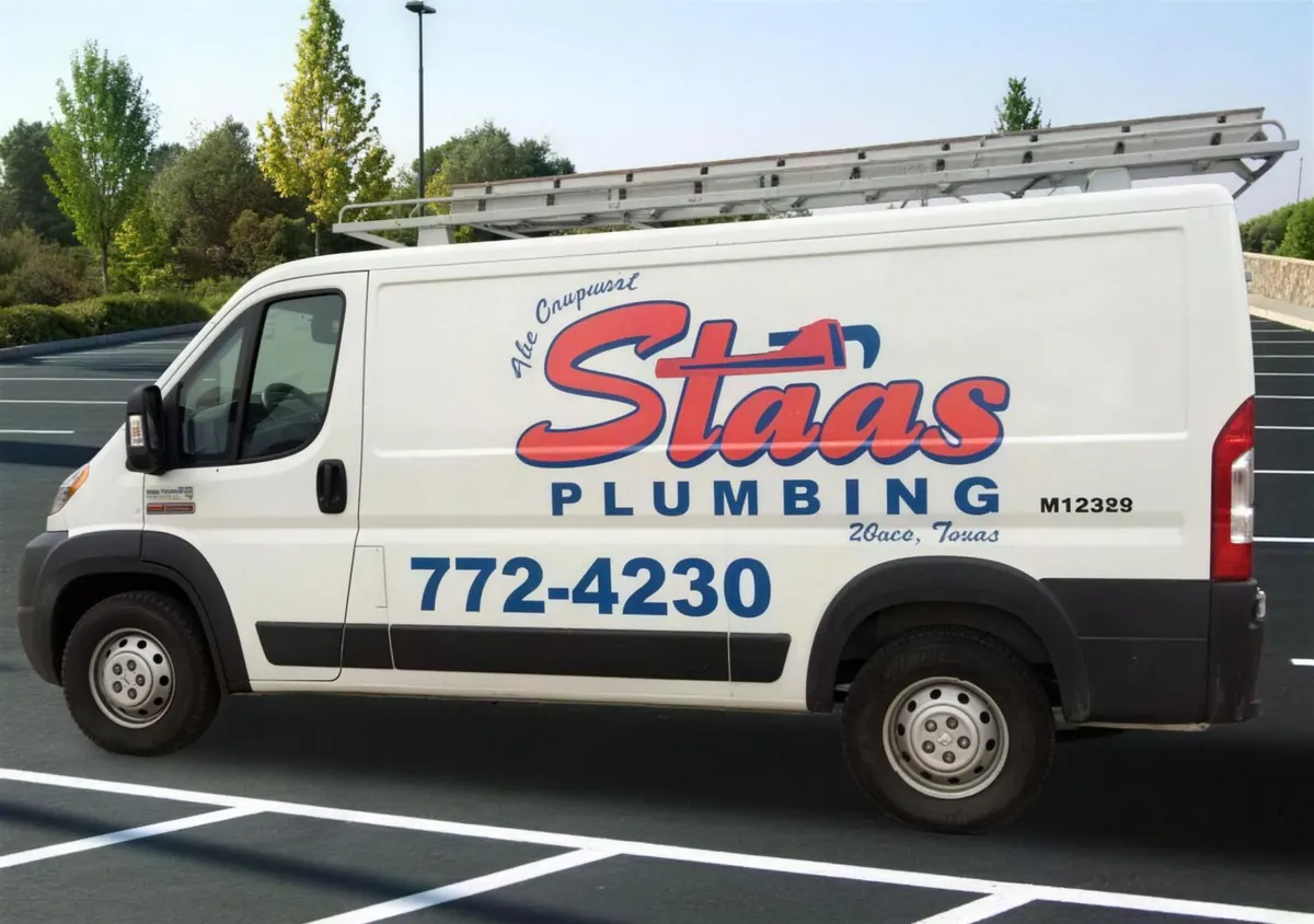 White Staas Plumbing service van with a ladder rack